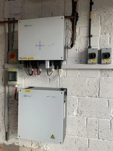 Two control boxes mounted on a brick wall, with various cables and switches visible.